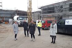 Bildunterschrift: Andrea Stollberg (Schulleiterin), Günter Voß (Klimaschutzmanager), Kordula Böhner (Architektin), Hermann Dickgreber (Projektleiter) und Bürgermeisterin Ute Dülfer im Innenhof des Klima-Campus. Rechts sieht man den neu errichteten Anbau.